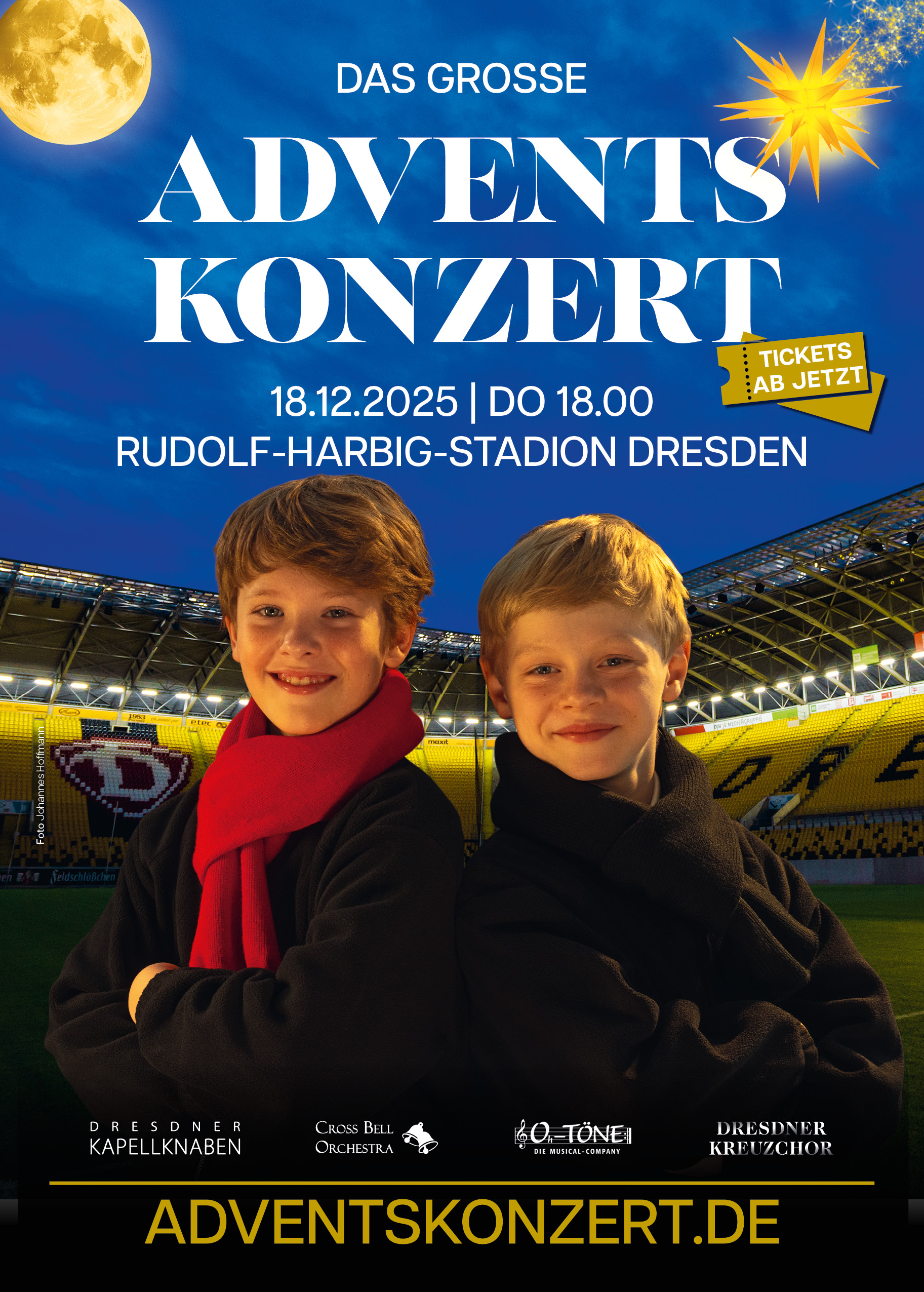 Plakat für „Das große Adventskonzert“ am 18.12.2025 um 18:00 Uhr im Rudolf-Harbig-Stadion Dresden. Im Vordergrund stehen zwei lächelnde Jungen in dunkler Kleidung mit roten Schals, vermutlich Mitglieder der Dresdner Kapellknaben. Im Hintergrund das beleuchtete Stadion mit weihnachtlichen Elementen wie Stern und Mond. Gelbes Banner mit dem Hinweis „Tickets ab jetzt“. Unten Logos der Mitwirkenden (Dresdner Kapellknaben, Clara Bell Orchester, O-Töne, Dresdner Kreuzchor) sowie die Website adventskonzert.de.